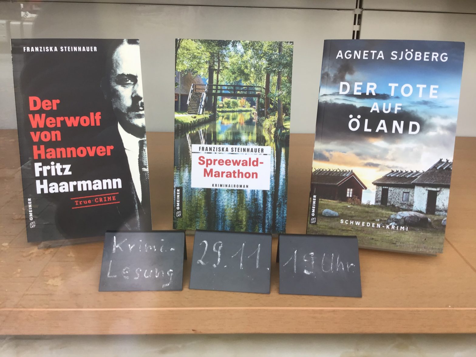 Ein Bild von drei Titel Franziska Steinhauers "Der Werwolf von Hannover", "Spreewald-Marathon", "Der Tote auf Öland", zusammen mit Kärtchen, auf denen steht "Krimi-Lesung, 29.11., 19 Uhr".