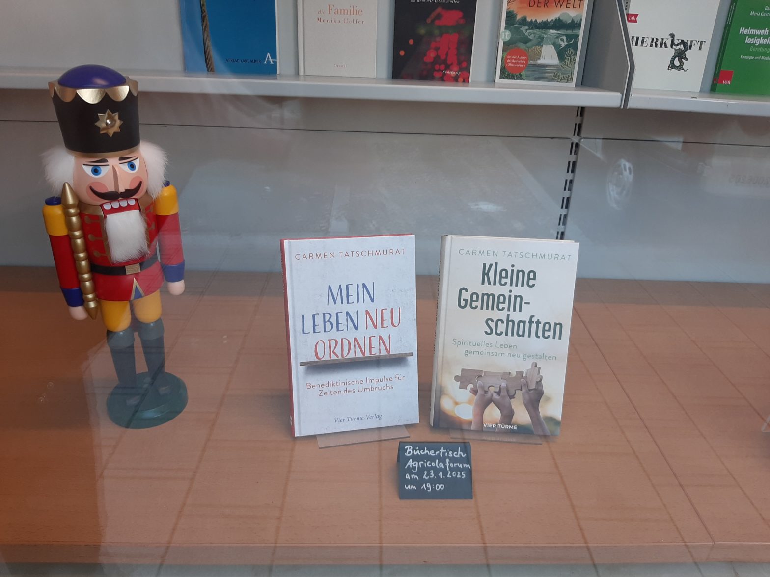 Foto des Schaufenster. Zu sehen sind die beiden Titel "Mein Leben neu ordnen" und "Kleine Gemeinschaften" von Schwester Carmen. Daneben steht ein Nussknackerkönig.